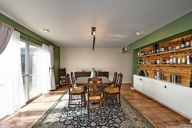 dining area with light tile patterned floors and bar