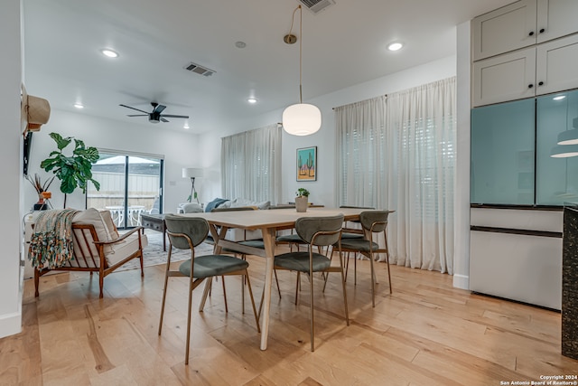 dining area with ceiling fan and light hardwood / wood-style floors