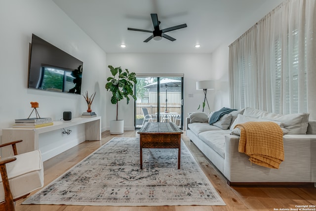 living room with ceiling fan and light wood-type flooring