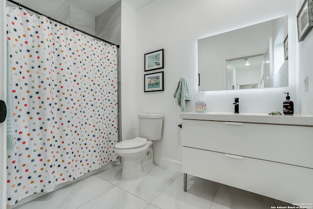 bathroom featuring curtained shower, tile patterned flooring, vanity, and toilet