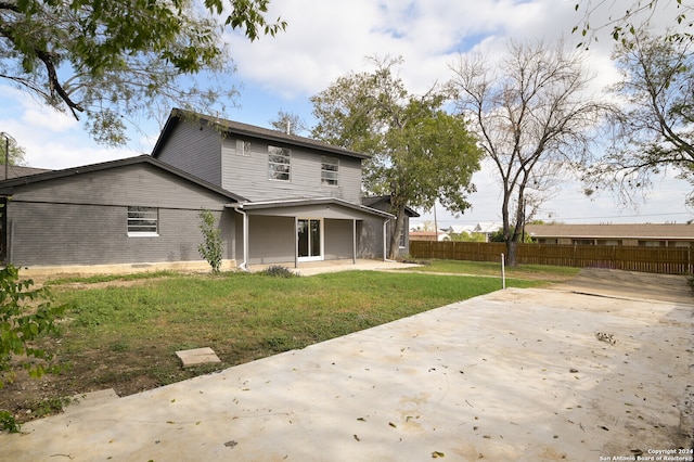 rear view of house featuring a lawn and a patio area