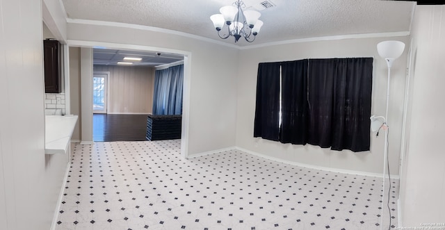 interior space featuring a notable chandelier, a textured ceiling, and ornamental molding