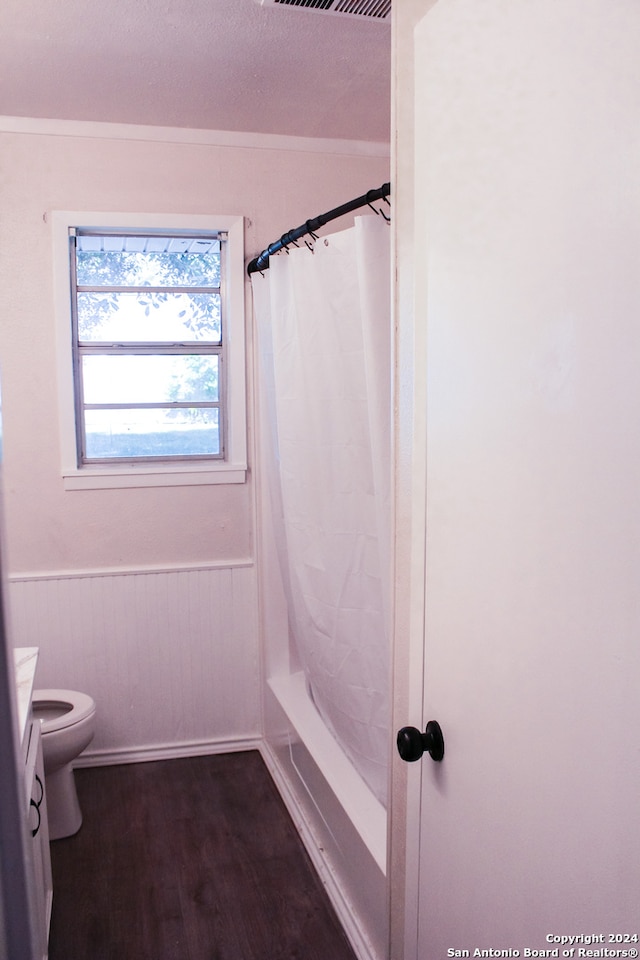 full bathroom featuring vanity, shower / bath combo with shower curtain, wood-type flooring, toilet, and wood walls