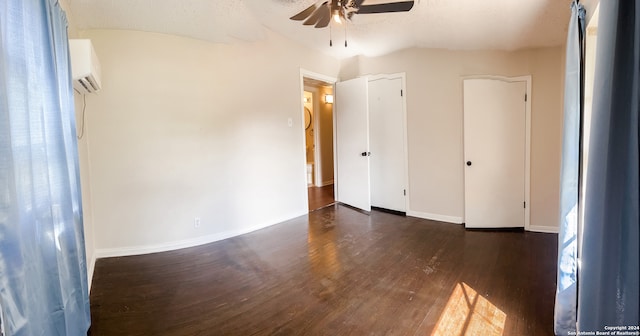 spare room featuring an AC wall unit, ceiling fan, a textured ceiling, and dark hardwood / wood-style floors