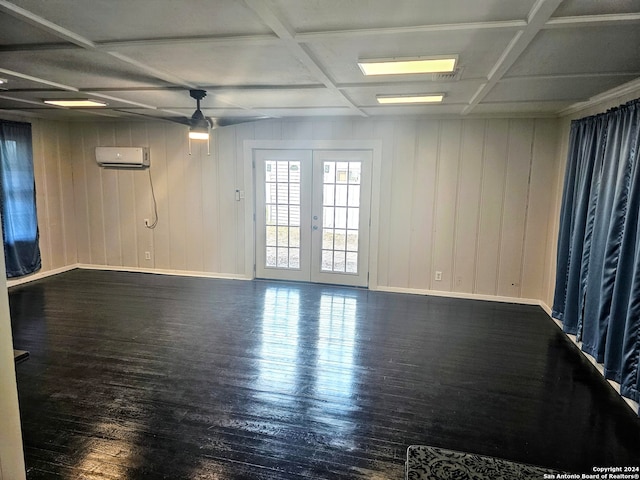 spare room featuring french doors, coffered ceiling, ceiling fan, an AC wall unit, and dark hardwood / wood-style floors