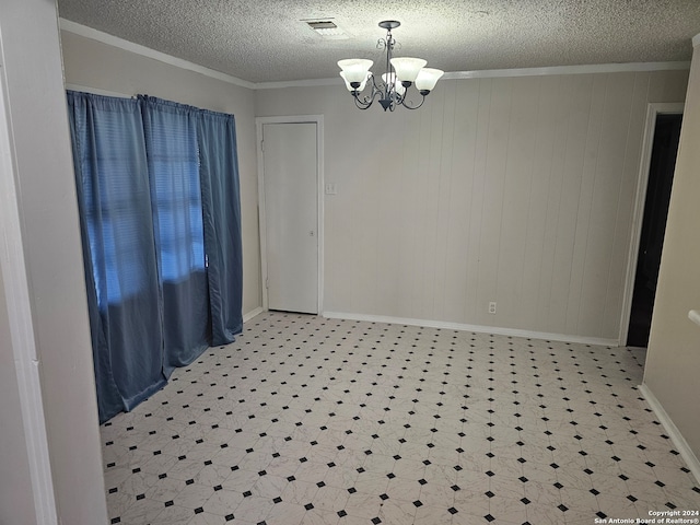 unfurnished dining area with crown molding, a textured ceiling, and a notable chandelier