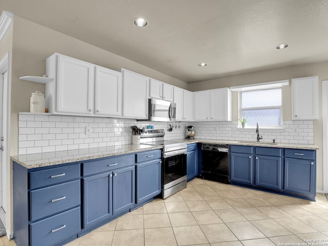 kitchen featuring blue cabinetry, white cabinetry, sink, light tile patterned floors, and appliances with stainless steel finishes