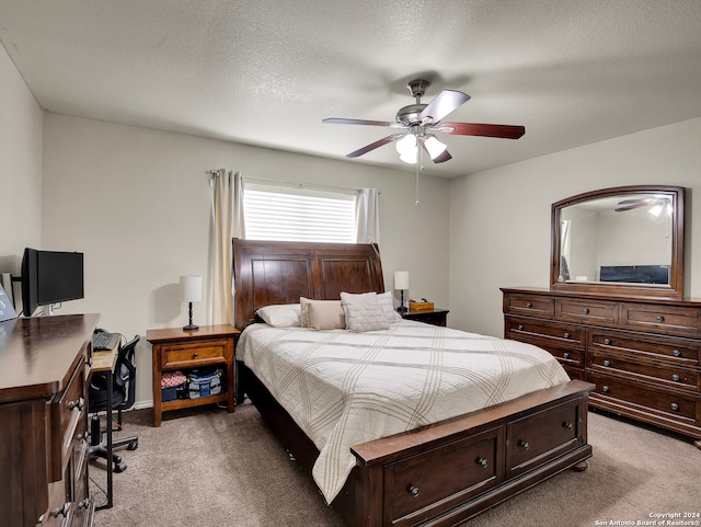 bedroom featuring light carpet, a textured ceiling, and ceiling fan