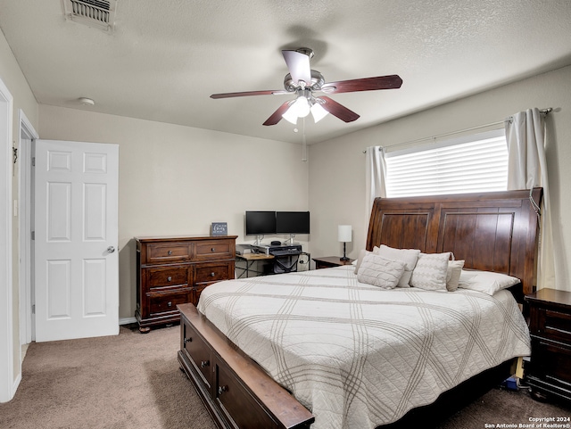 carpeted bedroom with ceiling fan and a textured ceiling