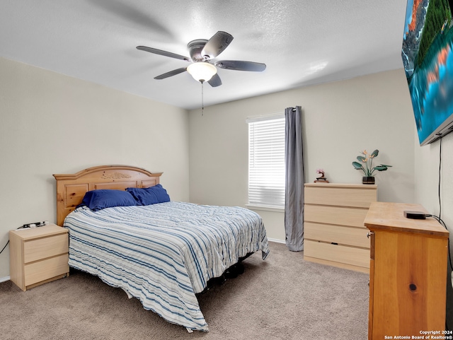 carpeted bedroom featuring ceiling fan and a textured ceiling