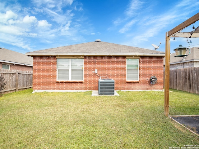 back of property featuring a lawn and cooling unit