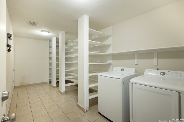 laundry room with washing machine and clothes dryer and light tile patterned floors