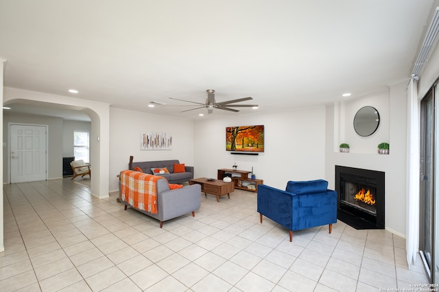 living room featuring ceiling fan, crown molding, and light tile patterned flooring