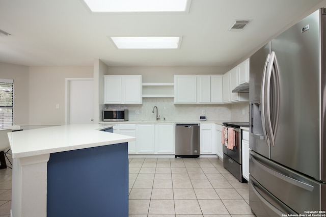 kitchen featuring backsplash, white cabinets, light tile patterned flooring, and appliances with stainless steel finishes