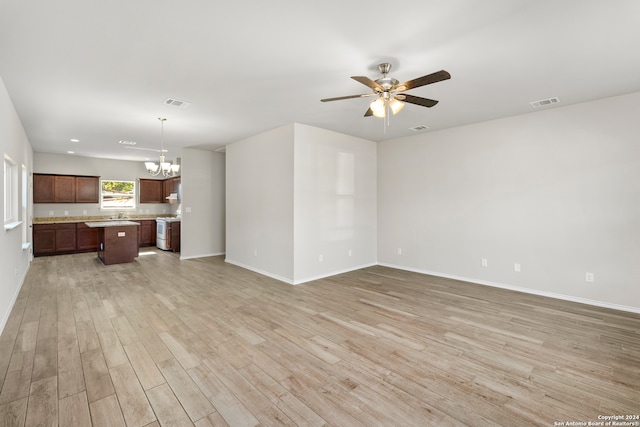 unfurnished living room with light hardwood / wood-style flooring and ceiling fan with notable chandelier