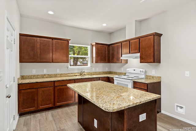 kitchen featuring electric range, a center island, light wood-type flooring, and sink