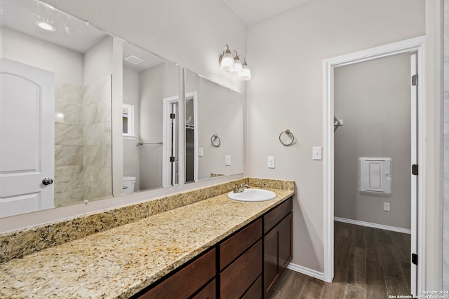 bathroom featuring wood-type flooring, vanity, and toilet