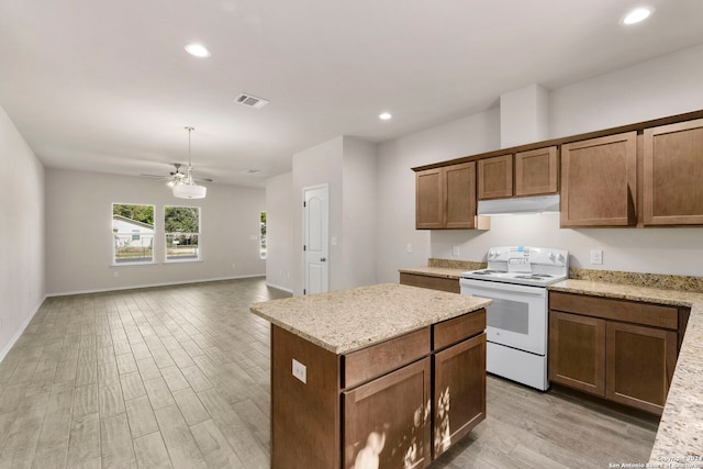 kitchen featuring a center island, light hardwood / wood-style floors, light stone countertops, and white electric stove