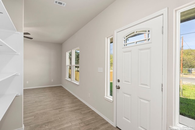 foyer entrance with ceiling fan, a wealth of natural light, and light hardwood / wood-style flooring