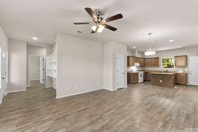 kitchen with ceiling fan, a center island, hanging light fixtures, white range with electric stovetop, and wood-type flooring