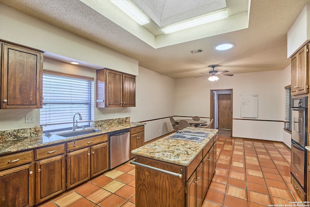 kitchen featuring a textured ceiling, ceiling fan, sink, and appliances with stainless steel finishes