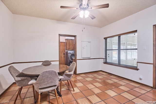 tiled dining space with ceiling fan, a textured ceiling, and washer / dryer