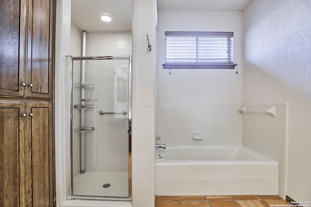 bathroom with tile patterned flooring, a textured ceiling, and shower with separate bathtub