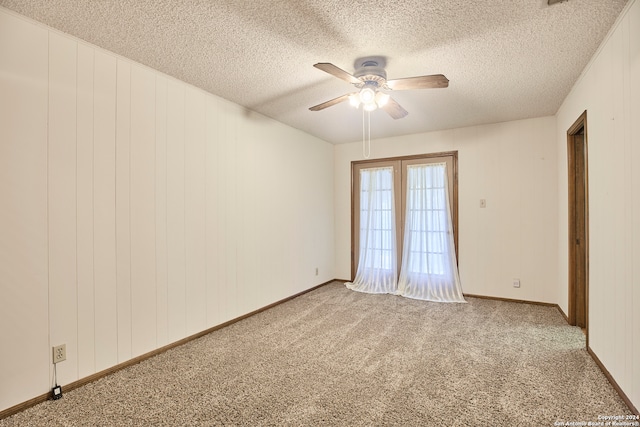 spare room featuring a textured ceiling, light colored carpet, and ceiling fan