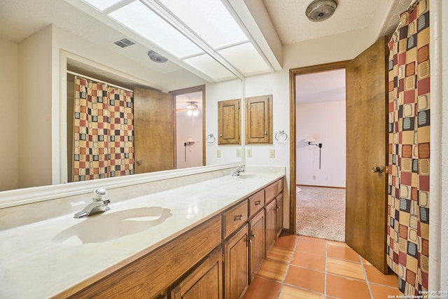 bathroom with tile patterned floors, vanity, and a textured ceiling