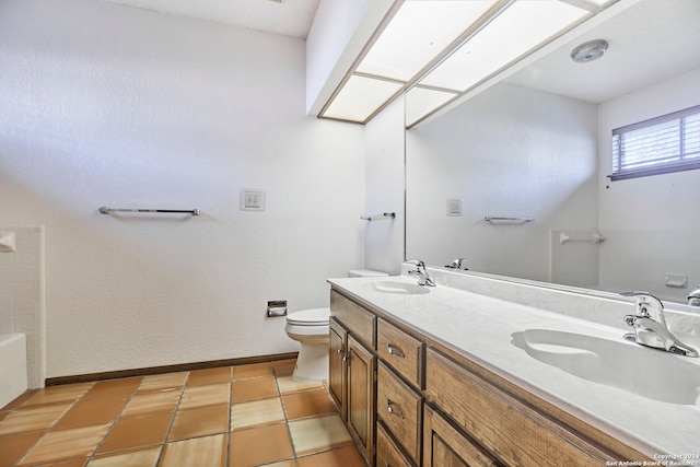 bathroom with tile patterned floors, a bathtub, vanity, and toilet