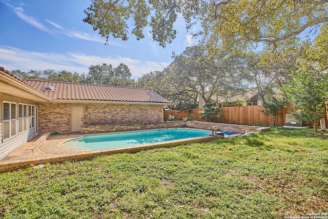 view of swimming pool featuring a yard and a patio area