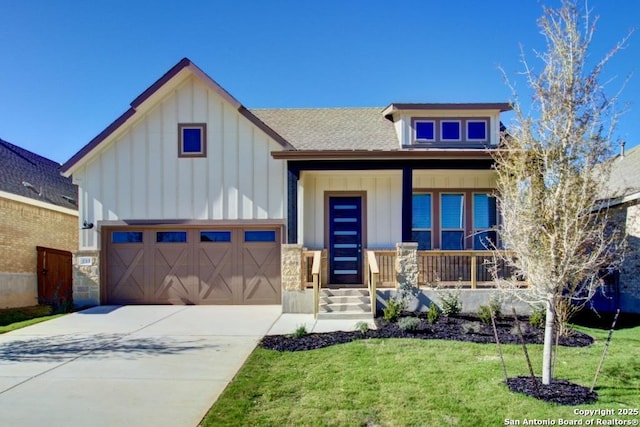 view of front of property featuring board and batten siding, a front yard, covered porch, driveway, and roof with shingles