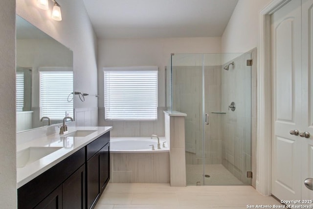 bathroom featuring a shower stall, a garden tub, and double vanity