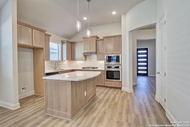 kitchen with stainless steel appliances, a sink, tasteful backsplash, light countertops, and light wood finished floors