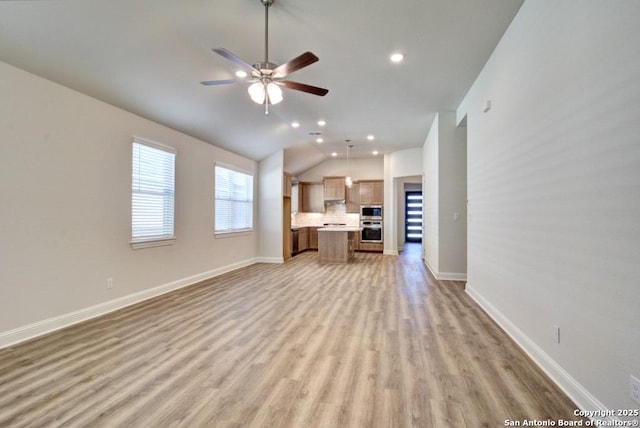 unfurnished living room with light wood-type flooring, lofted ceiling, ceiling fan, recessed lighting, and baseboards