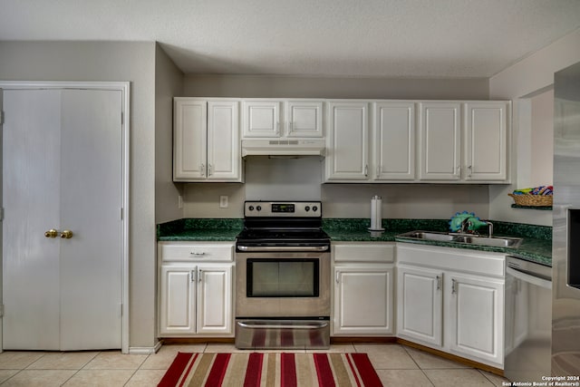 kitchen featuring sink, white cabinetry, stainless steel appliances, and light tile patterned floors