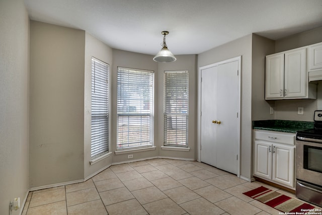 kitchen with white cabinetry, electric range, light tile patterned floors, and hanging light fixtures