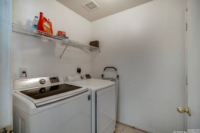 laundry area featuring washing machine and dryer and light tile patterned floors