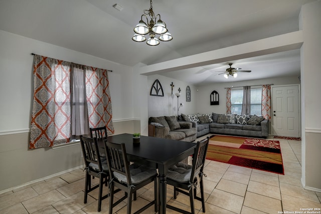 tiled dining space with ceiling fan with notable chandelier and lofted ceiling