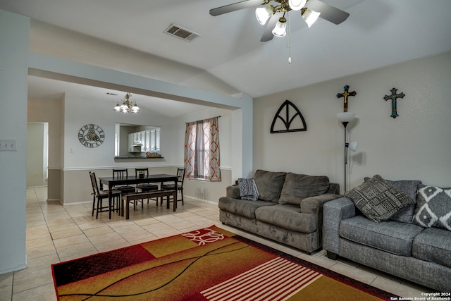 tiled living room with ceiling fan with notable chandelier and vaulted ceiling