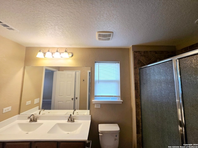 bathroom featuring vanity, a textured ceiling, toilet, and an enclosed shower