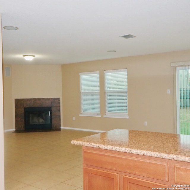 kitchen featuring light stone countertops and a tiled fireplace