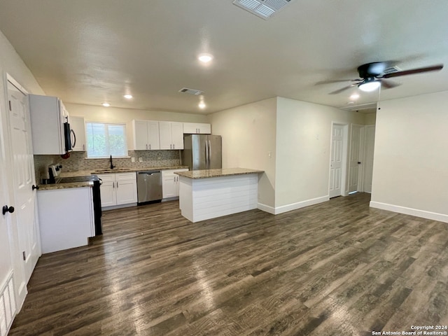 kitchen with white cabinets, appliances with stainless steel finishes, dark hardwood / wood-style floors, and sink