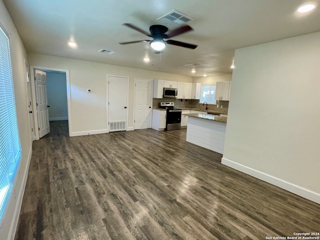 kitchen with dark wood-type flooring, ceiling fan, decorative backsplash, appliances with stainless steel finishes, and white cabinetry