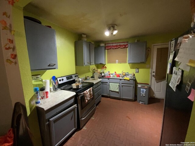 341 Avondale Ave, San Antonio, TX 78223 - kitchen featuring electric range, brick patterned floors, a sink, and gray cabinetry