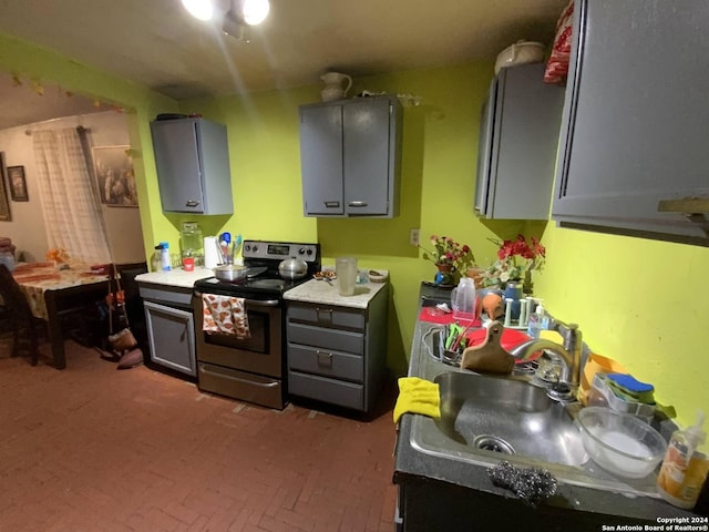 341 Avondale Ave, San Antonio, TX 78223 - kitchen with electric stove, a sink, brick patterned flooring, and gray cabinets