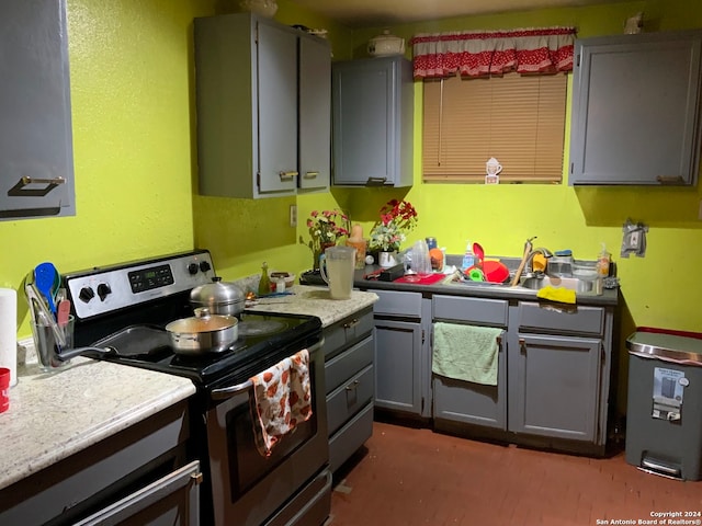 kitchen with gray cabinets, stainless steel electric stove, and sink