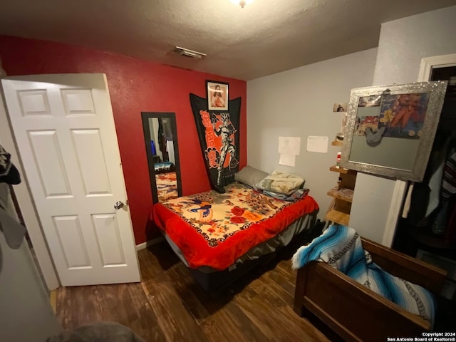 bedroom with dark wood-type flooring and a textured ceiling