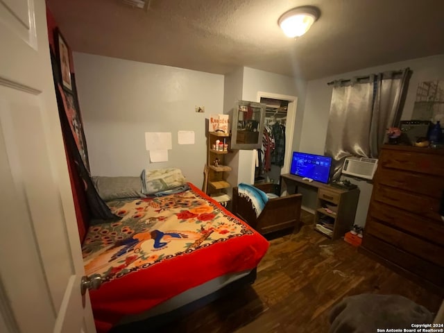 bedroom featuring a closet, dark wood-type flooring, and a textured ceiling