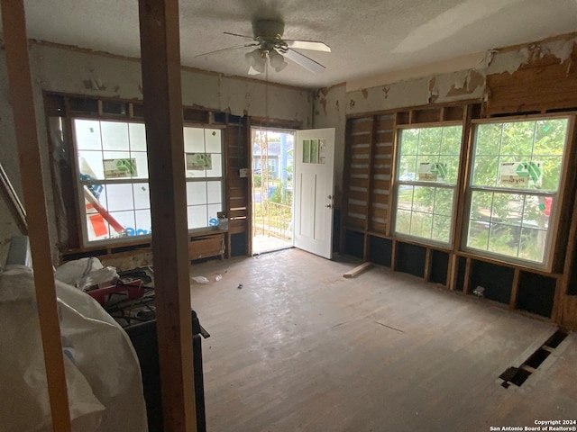 miscellaneous room with ceiling fan, a healthy amount of sunlight, a textured ceiling, and light wood-type flooring